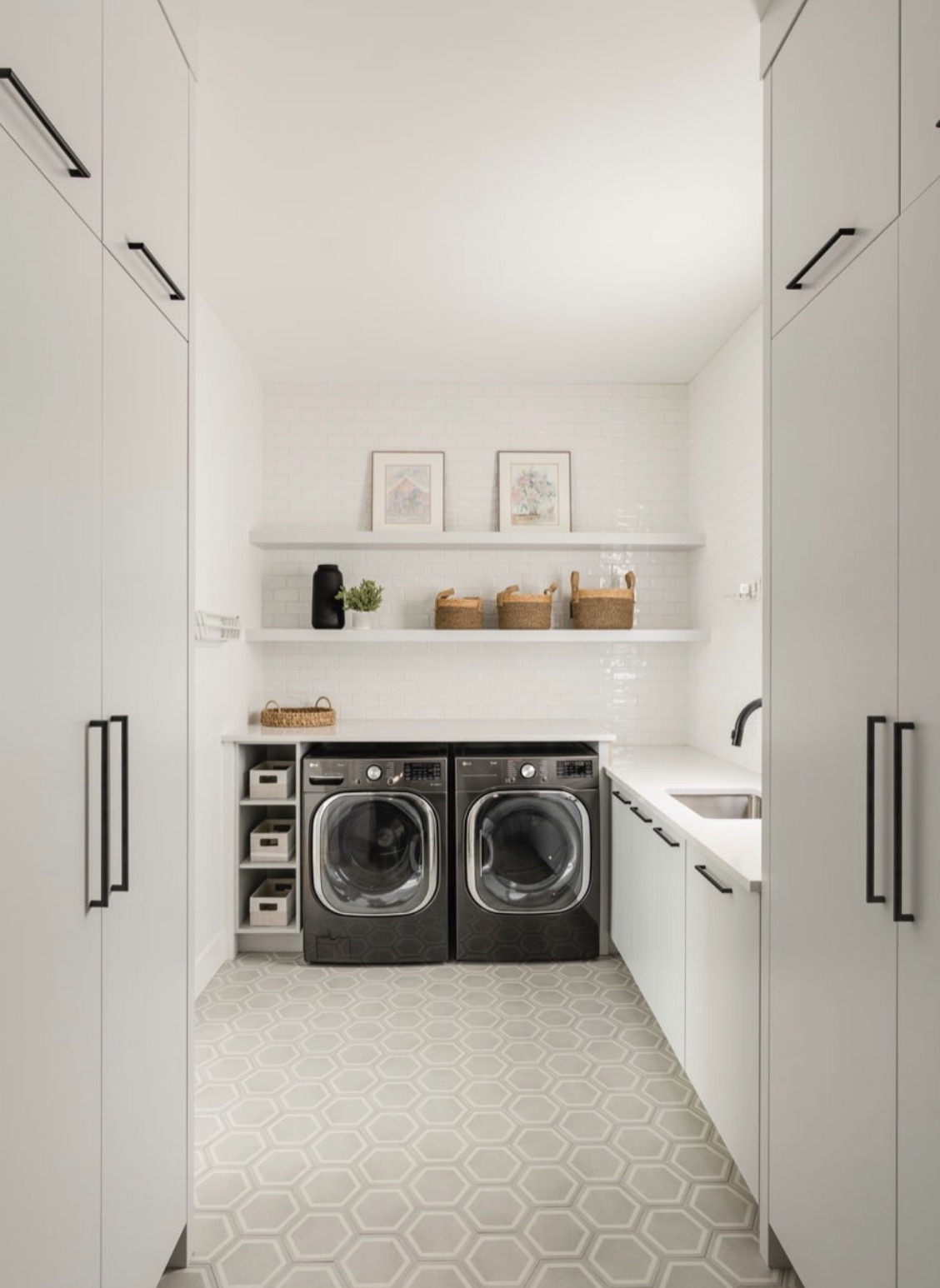 Laundry room with full-height cabinetry and patterned tile flooring
