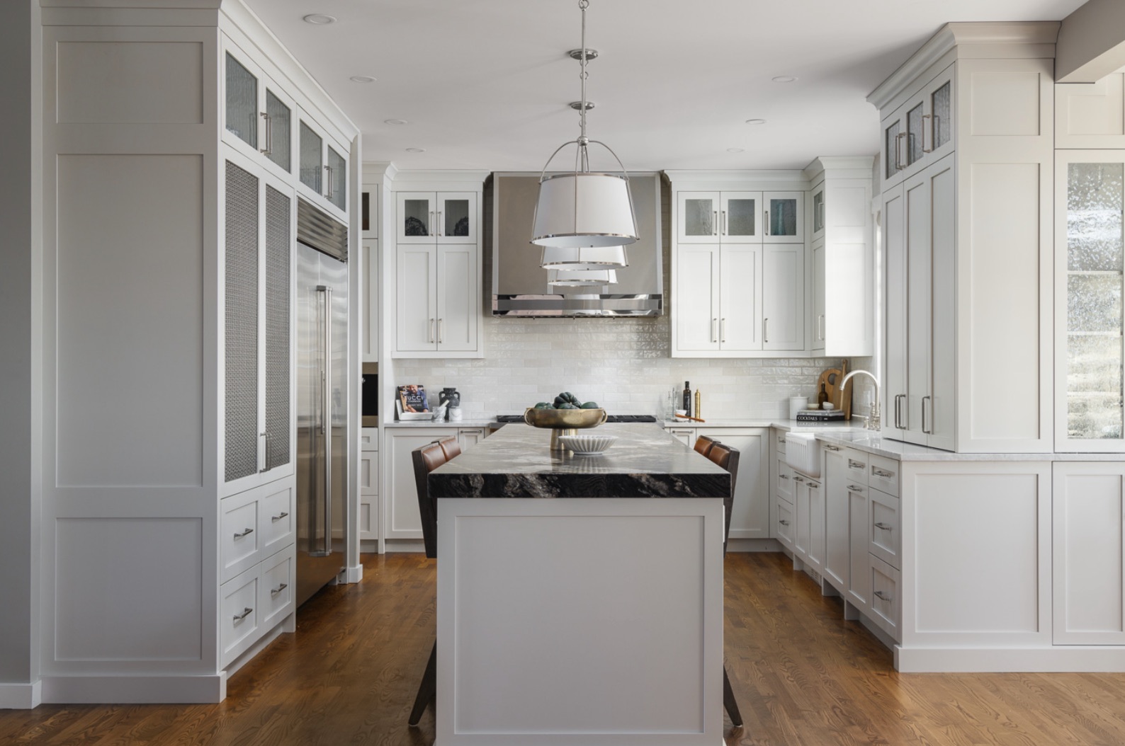 Wentworth Refresh kitchen with a dark stone island, tiered pendant and white cabinetry